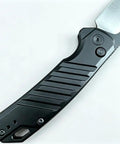 Close-up view of the milled aluminum handle of the No Hassle Button Lock Pocket Knife carrying a razor sharp two tone D2 steel blade.