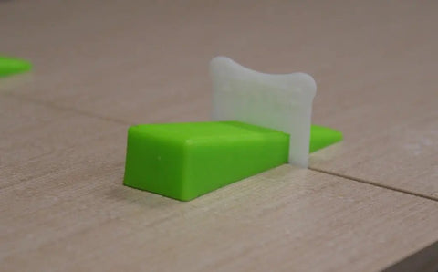 Tile Leveling Clips One Sixteenth Inch Five Hundred Piece Set For Flawless Floor And Wall Tiling Interlocking System Prevents Lippage While Adhesive Dries Easy Install Durable Construction Keeps Tiles Aligned showing clip inserted between tiles.