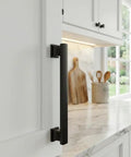25 Pack Flat Black Cabinet Pull Handles, 4 Inch Center-To-Center, close-up installed on white kitchen cabinet door