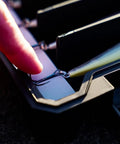 Close-up of a finger touching a hook inside BallistiX Twitch Tackle Tray For Jerkbaits And Topwaters Waterproof Lure Box with a lure visible.