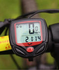 Compact LCD Bike Computer with Odometer and Speedometer mounted on handlebars displaying speed and time.