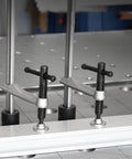 Quick Acting Desktop Hold Down Clamp For Woodworking Benches And Tables Handy Workholding Clip For Rapid Securing Fits 16mm And 28mm Holes Easy Grip Bench Fixture Clamp For Pros And DIYers installed on a metal table with 16mm holes