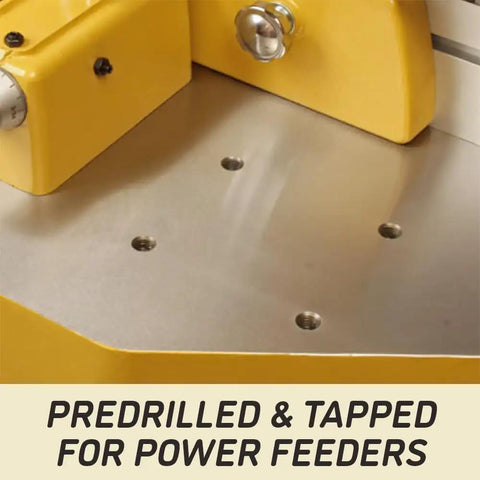 Close-up of Heavy Duty 5 HP Spindle Shaper With Cast Iron Base showing predrilled holes for power feeders on metal table.
