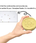 Hand holding a lid from Ten Pack Metal Bee Entrance Feeders 2.87 Inch For Beehives, reusable equipment for busy beekeepers