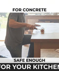 Person applying Pro Grade Water Based Concrete Countertop Sealer Kit Food Safe Formula on a concrete surface in a workshop.