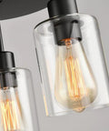 Close-up of Three Light Industrial Farmhouse Black Matte Ceiling Light Fixture with clear glass shades and visible filament bulbs