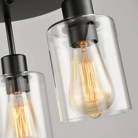 Close-up of Three Light Industrial Farmhouse Black Matte Ceiling Light Fixture with clear glass shades and visible filament bulbs