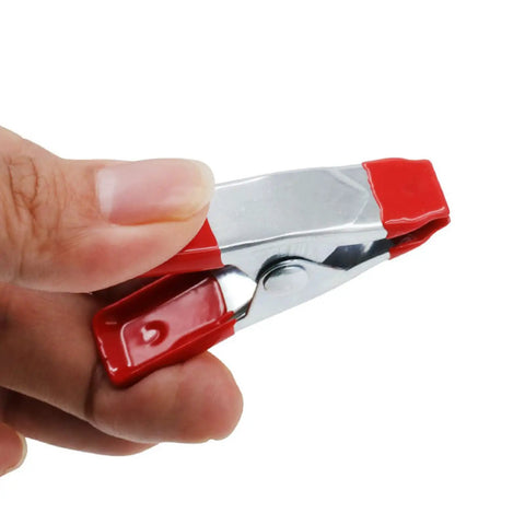 Close-up of a Heavy Duty Metal Spring Clamps 2 Inch Nonslip Clips for Photography and Woodworking, held in hand.