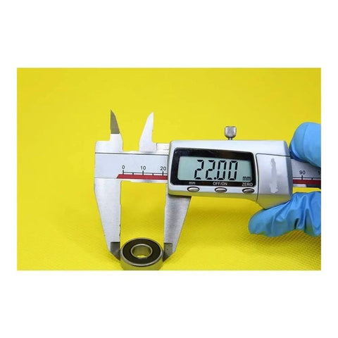 Measuring a 608 Hybrid Ceramic Ball Bearing size 22mm with calipers on a yellow background for accurate dimensions.