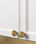 Antique Brass Cabinet Knobs 10 Pack Vintage Flat Drawer Pulls installed on white kitchen cupboard doors.