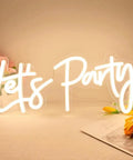 Versatile Dimmable Neon Sign For Parties And Events, 17x7.5 Inch Warm White Neon Lights For Wall Decor, "Let's Party" design on table