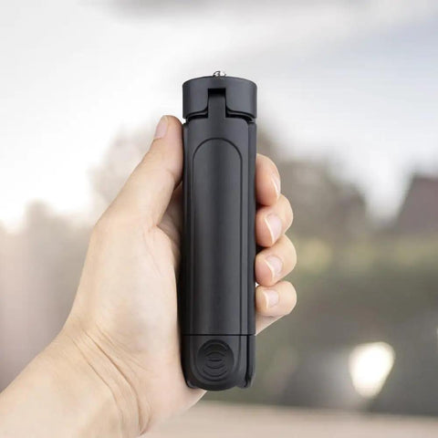 Person holding Pocket Sized 2 In 1 Mini Tripod Desk Stand And Handheld Grip, Ultra Lightweight 2 Oz, One Quarter Inch Mount