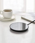 Top Shelf Electric Mug Warmer With Automatic Shut Off Keeps Your Coffee Tea And Water Nice And Toasty On Desk Or Nightstand Snug Little Heater in glossy black next to a cup.