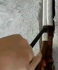 Person using Heavy Duty Manual Pipe Bender Tool For Spring Wire And Water Conduit Bends on thick pipes against a wall.