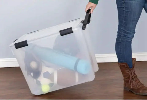 Clear Plastic Storage Bin With Locking Lid Rolling Wheels Weather Tight Seal And Clear Design Provides Lockdown Protection From Moisture Dust And Debris Plus Secure Grip Handles being pulled by a person.