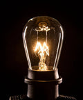 Close-up of a glowing bulb from the Beefed-Up 100 Foot Outdoor Commercial String Lights With E26 Suspended Sockets, Weatherproof Vintage Exterior Lighting, 50 S14 11W Bulbs, 100 Ft Run For Patio And Backyard Parties, Built To Last.