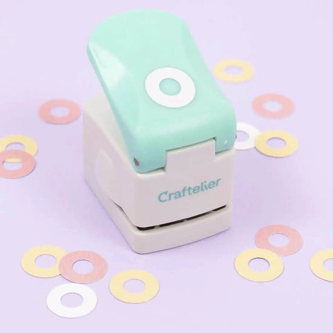 Circle Punch With Reinforcing Ring And Snap Lever for paper crafting, shown with turquoise lever and decorative grommets.