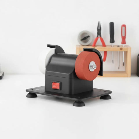 Solid Compact Corded Electric Bench Grinder Tool Polisher Cutter With Dual Wheel Setup, black casing and red wheel on workbench.