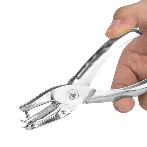 Hand holds a one handed hole punch for paper, 6 sheet capacity, 3.175mm hole, chrome plated handheld puncher with scrap collector