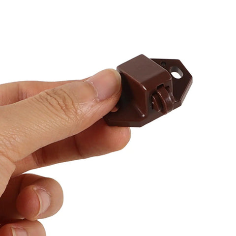 Close-up of brown latch from 20 Pack Plastic Ball Catch Latches For Cabinets And Cupboards, suitable for drawer doors.