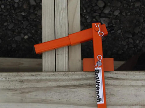 BW90 11 Universal Bowrench Deck Tool used for straightening wood deck boards with adjustable orange gripper on wider joists.