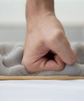 High Density Egg Crate Acoustic Foam Roll With Rock Solid Self Adhesive Backing being compressed by a hand on a surface.