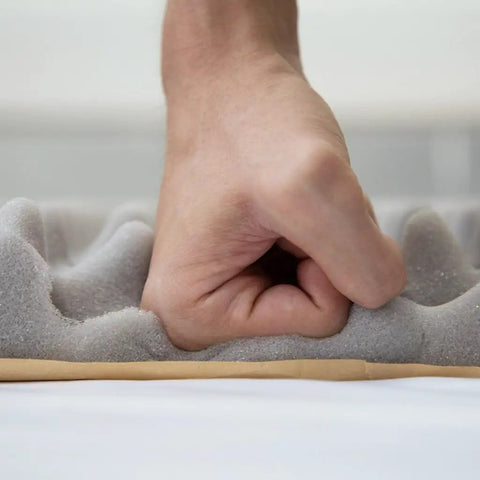High Density Egg Crate Acoustic Foam Roll With Rock Solid Self Adhesive Backing being compressed by a hand on a surface.