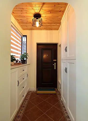 Dope Industrial Semi Flush Mount Ceiling Light Featuring A Sick Black Cage Design And Rustic Vintage Vibe Perfect For Compact Rooms With Easy E26 Led Compatibility And Badass Farmhouse Decor Accents illuminating a hallway.