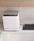 Nifty Countertop Dishwasher on kitchen counter with sink, compact size, stainless steel tub, auto air dry feature.