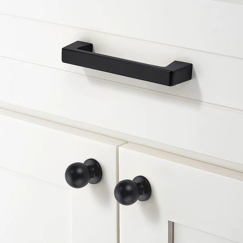 Matte black cabinet pull installed on white cabinet; 20 Pack Matte Black Cabinet Pulls Center To Center Three And Quarters Inches With Four Point Four Inch Overall Length Half Inch Inches One And Quarter Inch Projection Includes One And One Quarter Inch Screws.