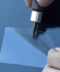 Close-up of Windshield Chip And Crack Repair Kit With Nano Resin being applied to car windshield with plastic film layer