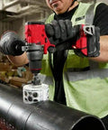 Worker using Badass 18V 1/2-Inch Compact Cordless Drill Driver Bit Socket Adapter on metal pipe in job site.