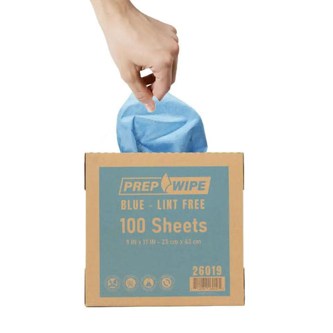 Hand pulling a blue towel from a box labeled Heavy Duty Lint Free Cleaning Towels For Auto Body And Industrial Prep, Solvent Resistant Wipes, 100 Pack, 9x17 In.