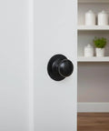 Matte Black Escutcheon Back Plates For Cabinet Knobs And Doors Four Pack Round Rosette Plate Two And One Third Inch Heavy Duty Die Cast Zinc Ideal For Bifold Closet Doors Door Pulls And Handles installed on a white door