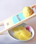 Wave Waffle Crinkle Cutter Set with wooden frame and stainless blade; hand slicing a potato into crinkle fries.