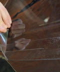 Clear 2 Inch By 24 Inch Universal Adhesive Window Film For Convertible Tops being applied to car window