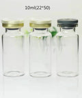 Front view: three 10ml clear glass vials with aluminum flip-off caps (gold and gray), empty lab sample bottles.