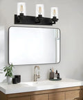 Bathroom scene with a Three Light Matte Black Vanity Light With Seeded Glass Shades above a sink and mirror setup.