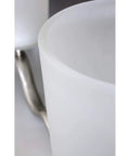 Close-up of Inspire Collection Four-Light Bath Vanity Light with etched glass shade and brushed nickel finish arm.