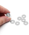 Seven M4 stainless steel flat washers, 12 mm outer diameter, 1 mm thick; one held between fingers.