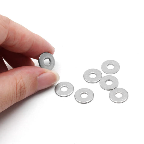 Seven M4 stainless steel flat washers, 12 mm outer diameter, 1 mm thick; one held between fingers.