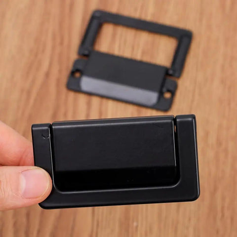Close-up of a foldable black zinc alloy drawer pull, highlighting space-saving design. 2 Pack Foldable Zinc Alloy Drawer Pulls For Cabinets And Furniture Hidden Metal Handles In Black Space Saving Durable And Corrosion Resistant 7.4 By 4 Cm Easy Install.