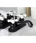 Black lavatory faucet with porcelain cross handles on a bathroom countertop reflective surface.