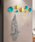 Built Different Wall Mounted Coat Hooks For Entryway with yellow and blue circles, gold hooks, holding a striped coat.