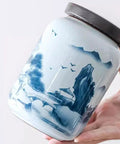 Top Shelf Airtight Ceramic Tea Canister Keeping Freshness Locked Inside Retro Blue And White Landscape Vibes Large Pantry Storage Jar For Coffee Beans, shown in hand with intricate blue design.