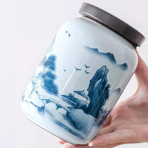 Top Shelf Airtight Ceramic Tea Canister Keeping Freshness Locked Inside Retro Blue And White Landscape Vibes Large Pantry Storage Jar For Coffee Beans, shown in hand with intricate blue design.