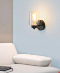 Matte Black Metal Wall Sconces With Clear Glass Shades Two Pack Modern Bathroom Vanity Lights Brushed Brass Finish Easy Mount Wall Light Fixtures For Bath And Hallway illuminating a modern living space.