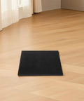 Black protective foam padding sheet on wooden floor, ideal for shipping electronics, glassware, and small business packaging.