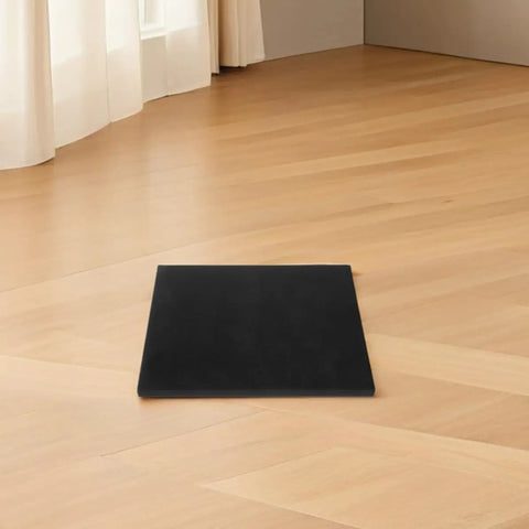 Black protective foam padding sheet on wooden floor, ideal for shipping electronics, glassware, and small business packaging.