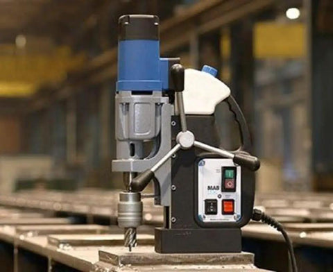 Heavy Duty Reversible Magnetic Drill With Rock Solid Grip And 10.5 Amp Motor crushing steel with drill bit in industrial setting.